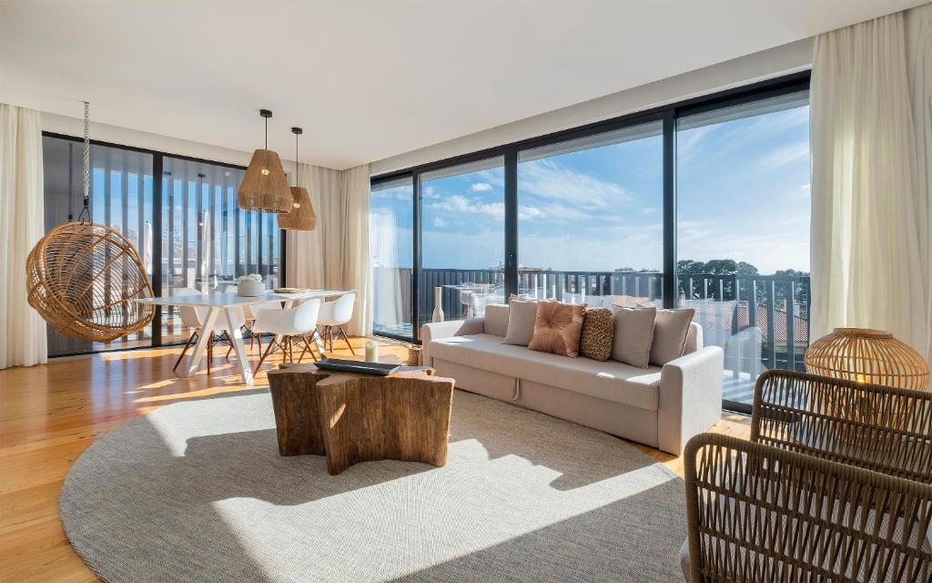 a living room with a white couch and a table at Aqua - Pópulo Eco Village in Ponta Delgada