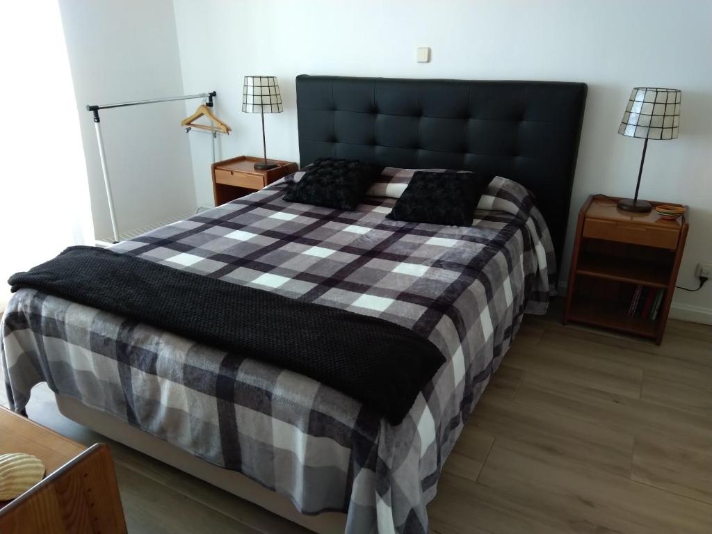 ein Schlafzimmer mit einem großen Bett mit einer karierten Decke in der Unterkunft Casa Gomikika in São Brás de Alportel