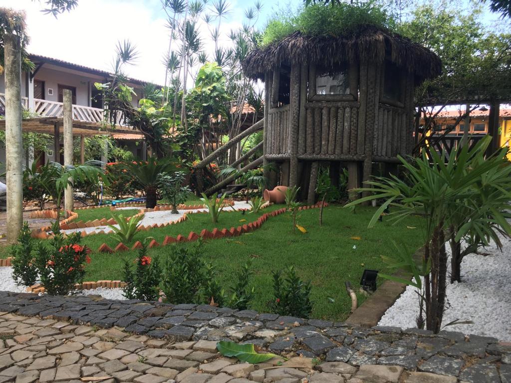 un jardín frente a un complejo con un edificio en Hotel Pousada Dos Ventos, en Parnaíba