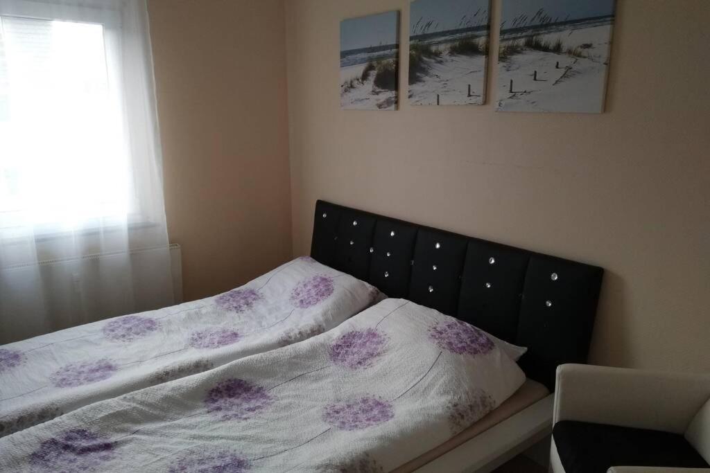 a bedroom with a bed with purple flowers on it at Nice Appartement near TradeFair and City 8 Min. in Cologne