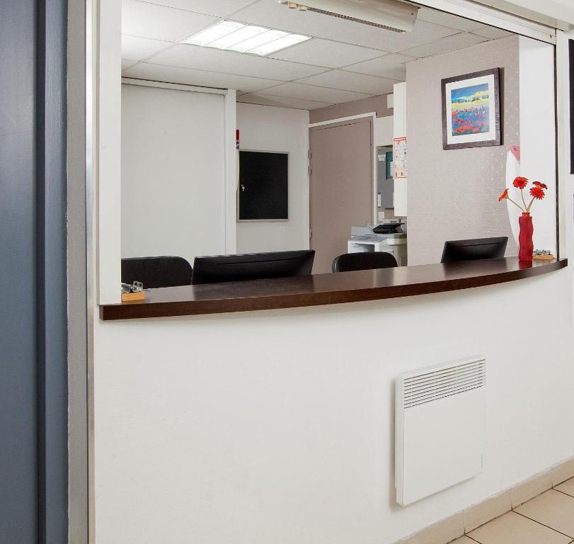 an office with a waiting room with black chairs at Séjours &amp; Affaires Nantes La Beaujoire in Nantes