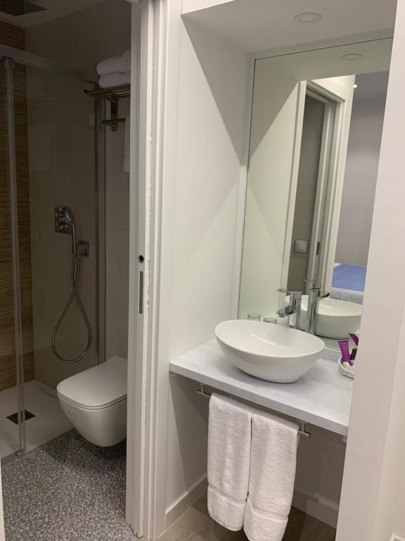 a bathroom with a sink and a toilet and a mirror at Nerja Casual Rooms in Nerja