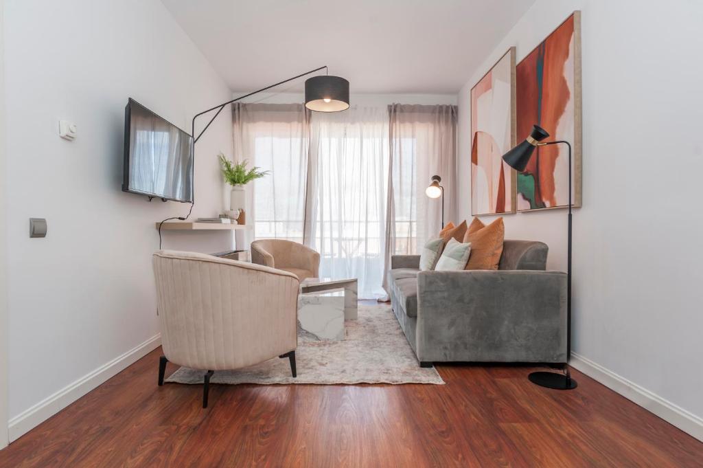 ein Wohnzimmer mit einer Couch und einem Sessel in der Unterkunft Tu Escapada Urbana - Plaza de Castilla III, Diseño y Localización in Madrid