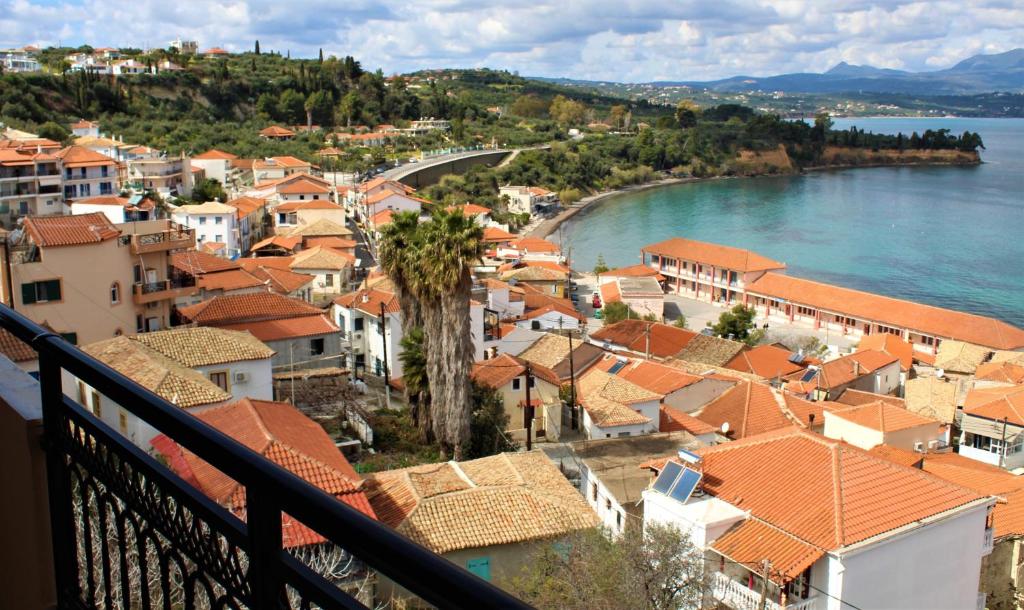 a view of a town with orange roofs and water at Balcony of Koroni in Koroni