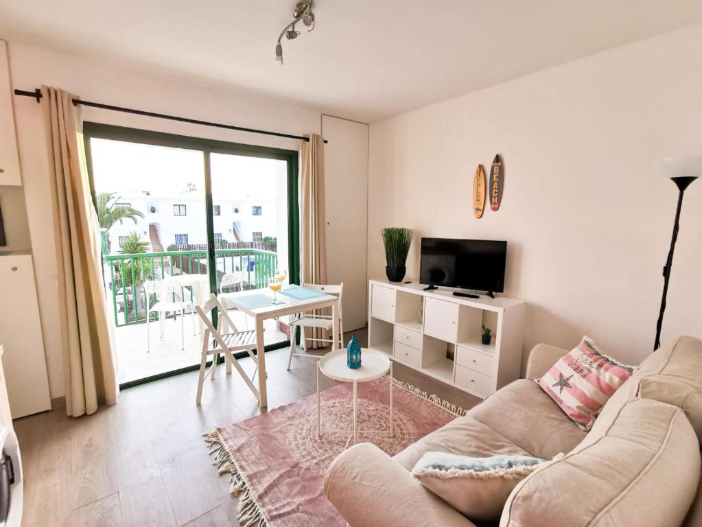 un soggiorno con divano e tavolo di Endless Summer apartment (San valentin) a Corralejo