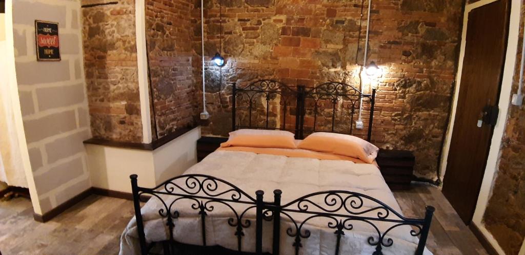 a black bed in a room with a brick wall at Il Vico in Serra San Bruno