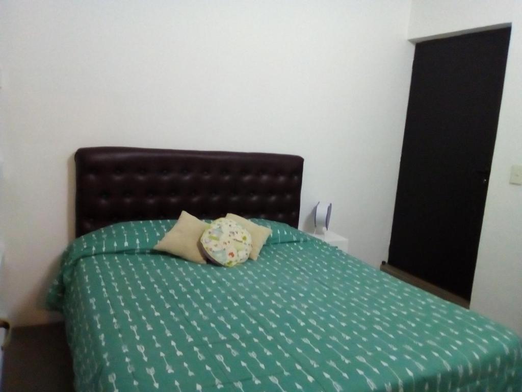 een slaapkamer met een bed met een groen dekbed bij los cerros pb in Bariloche