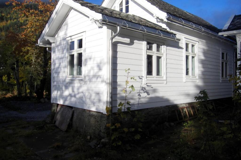 ein weißes Haus mit einem Seitenfenster in der Unterkunft Trolltunga, Jondal, Sommerski in Jondal