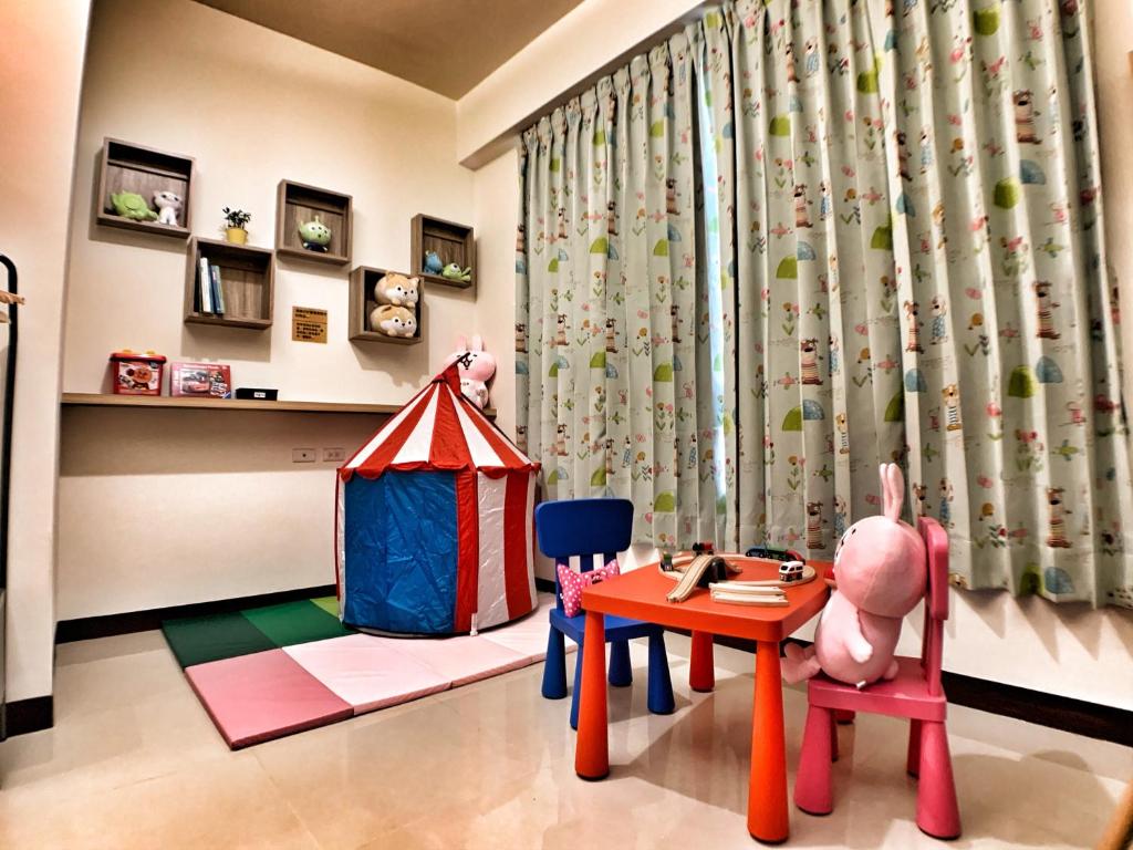 een kinderkamer met een speeltent en een tafel en stoelen bij The Sunny Homestay in Puli