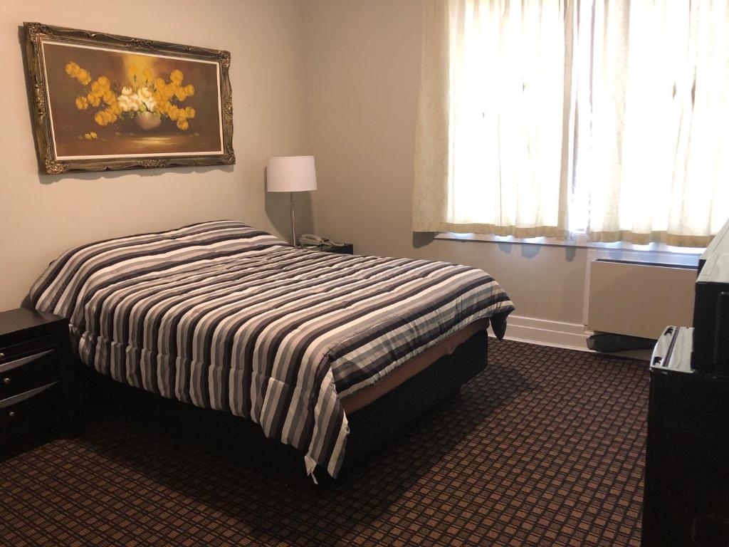 ein Schlafzimmer mit einem Bett und einem Wandgemälde in der Unterkunft Royal Hotel in Flin Flon