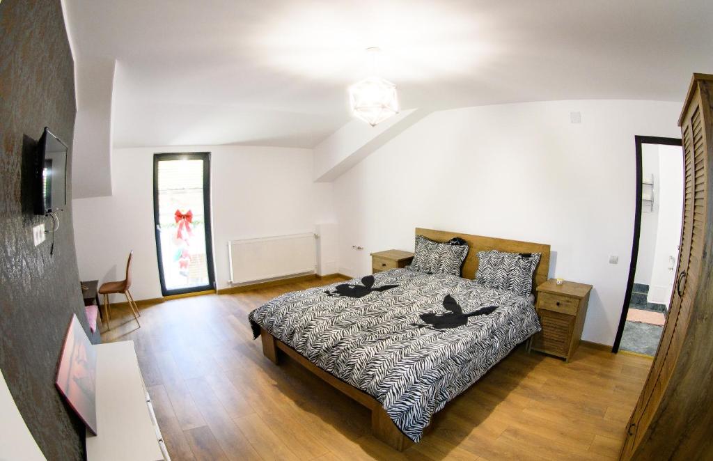 a bedroom with a bed and a table in it at Ayana Central House in Oradea