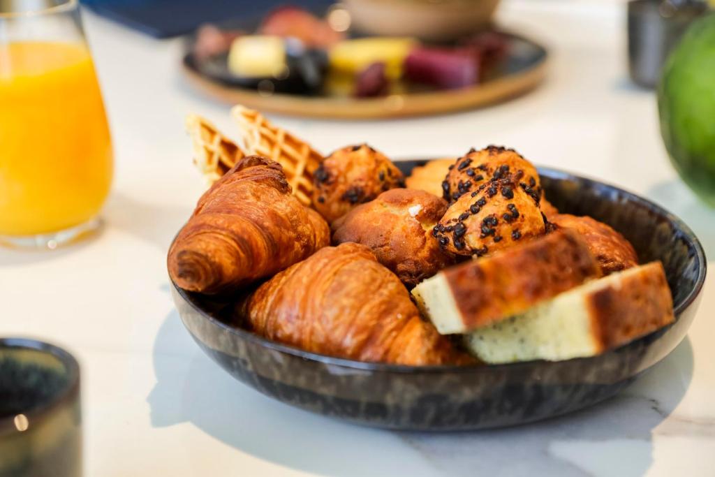 a bowl of bread and pastries on a table at Maison Albar - Le Vendome in Paris