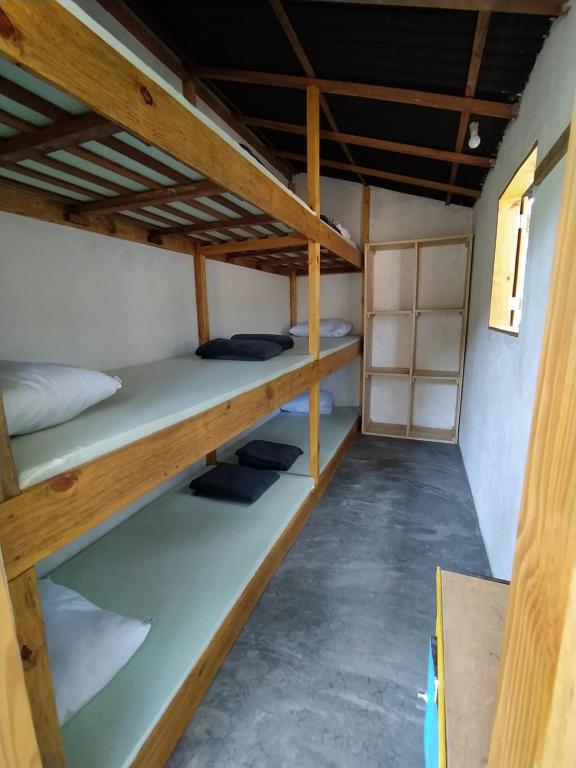 um quarto com três beliches em Kombi Hostel Camping em Vale do Capão