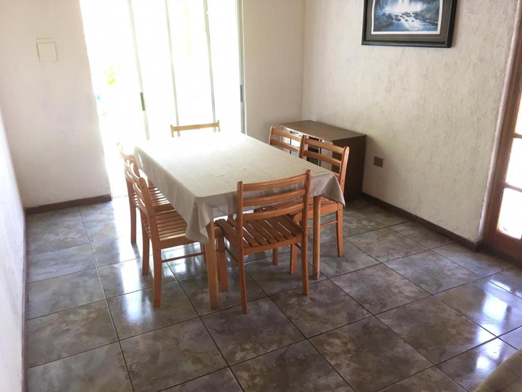 a dining room with a table and four chairs at Hermosa casa familiar para 8 personas - Cochiguaz Valle de Elqui in Paihuano