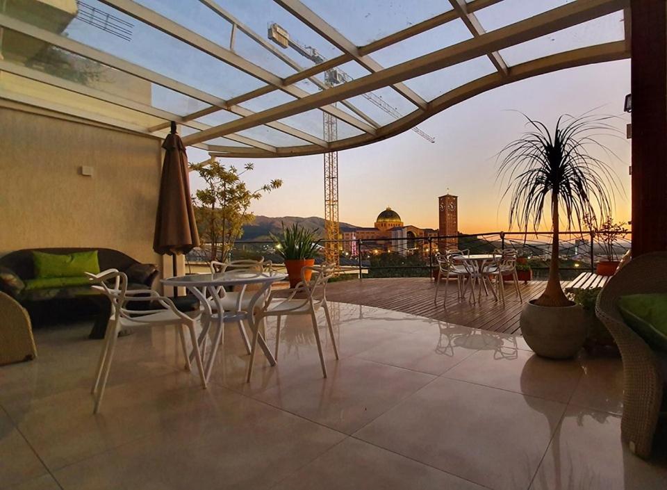 a patio with tables and chairs and a view of the city at Marge Hotel in Aparecida