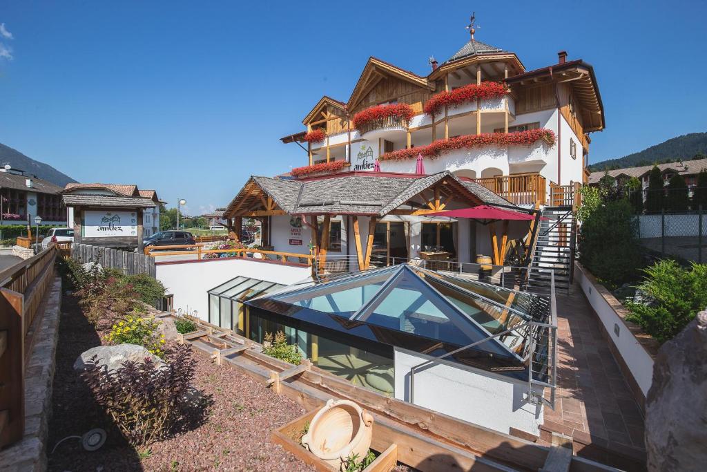 a large house with a glass roof in front of it at Hotel Ambiez in Andalo