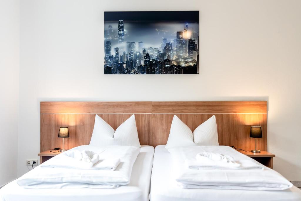 شقق هوتيل فريش إن في أونترهاخينج: سريرين في غرفة الفندق مع صورة على الحائط