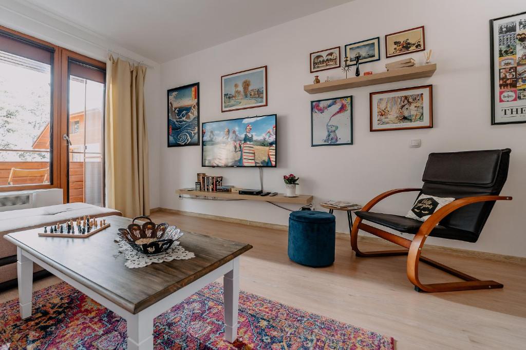 ein Wohnzimmer mit einem Tisch und einem Stuhl in der Unterkunft Veli Hills Apartments in Welingrad