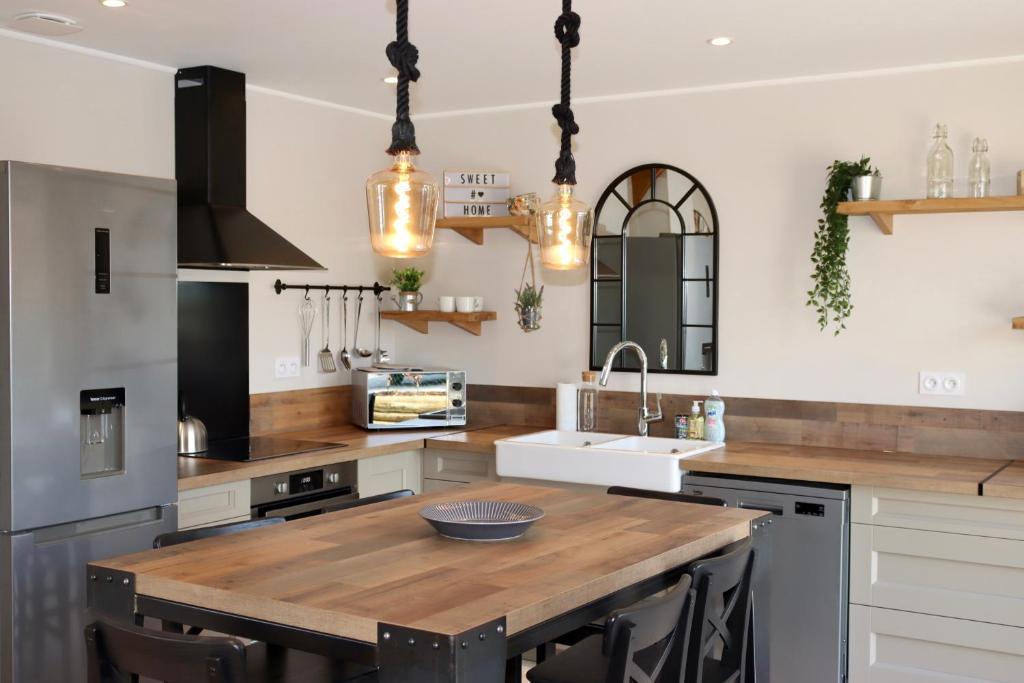 a kitchen with a wooden counter top and a sink at Les maisons de Charlotte (2) in Glanville