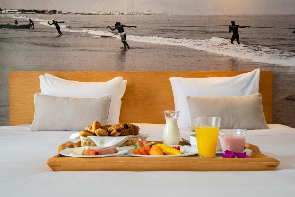 a tray of food on top of a bed with the beach at Delirio Hotel in Cartagena de Indias