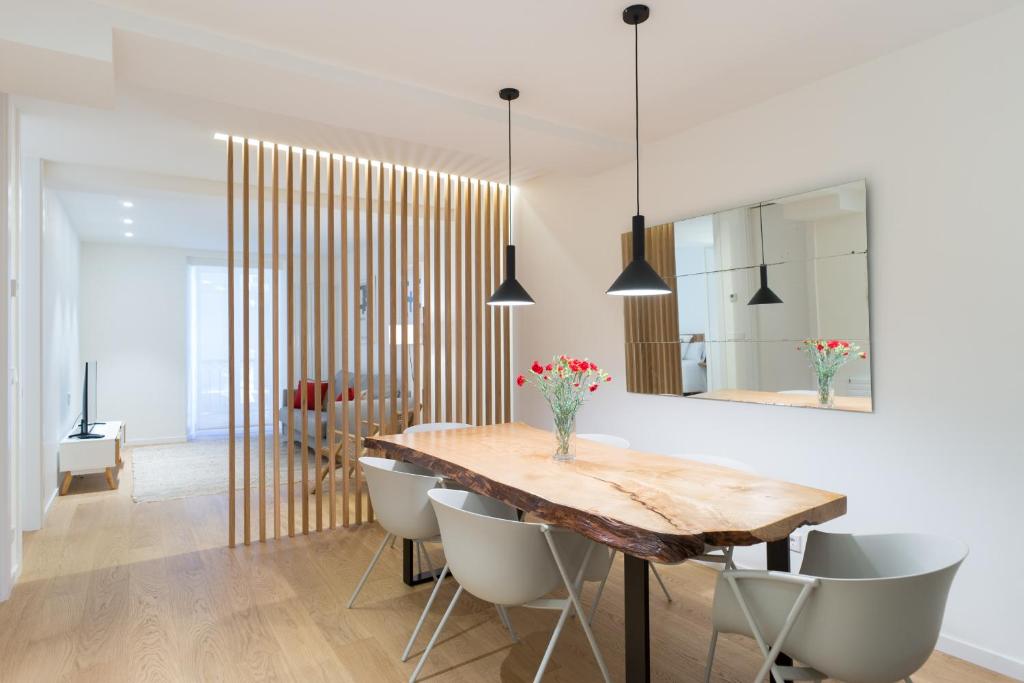 een eetkamer met een houten tafel en stoelen bij Fermin Suite - Iberorent Apartments in San Sebastian