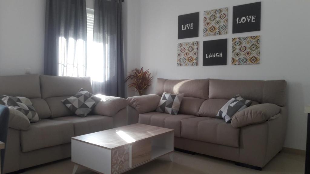 een woonkamer met een bank en een salontafel bij Vivienda Turística Ronda del Carmen in Bujalance