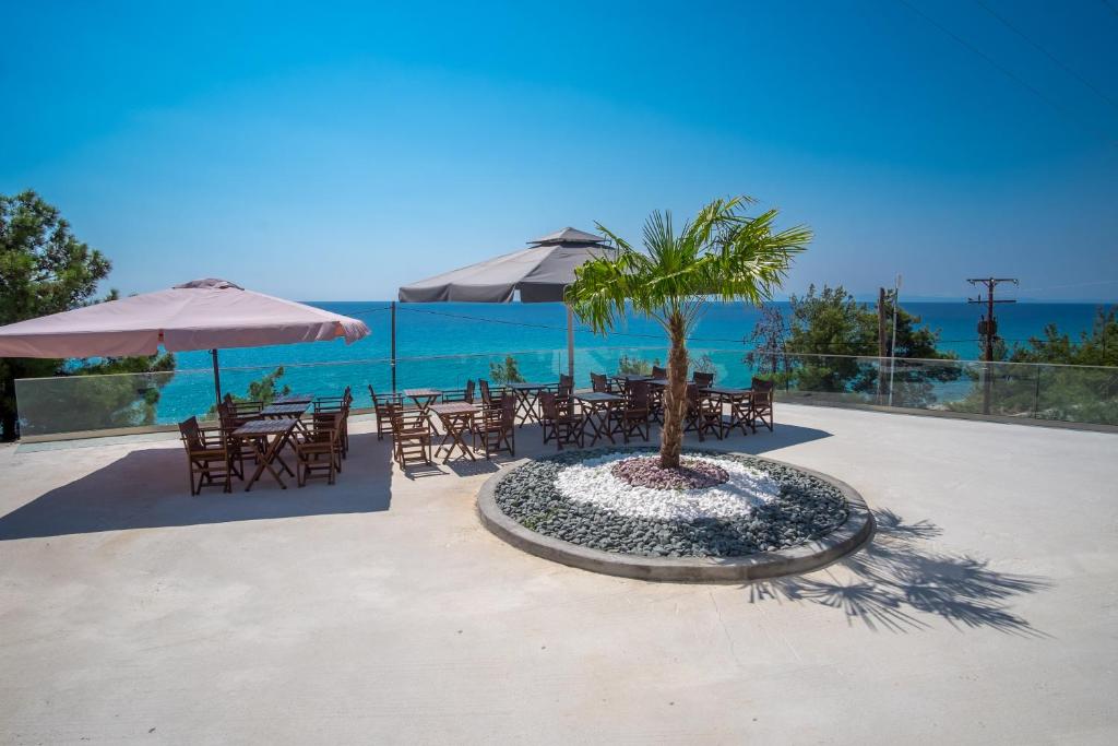 a table and chairs with a palm tree on the beach at Life's Moments in Limenaria