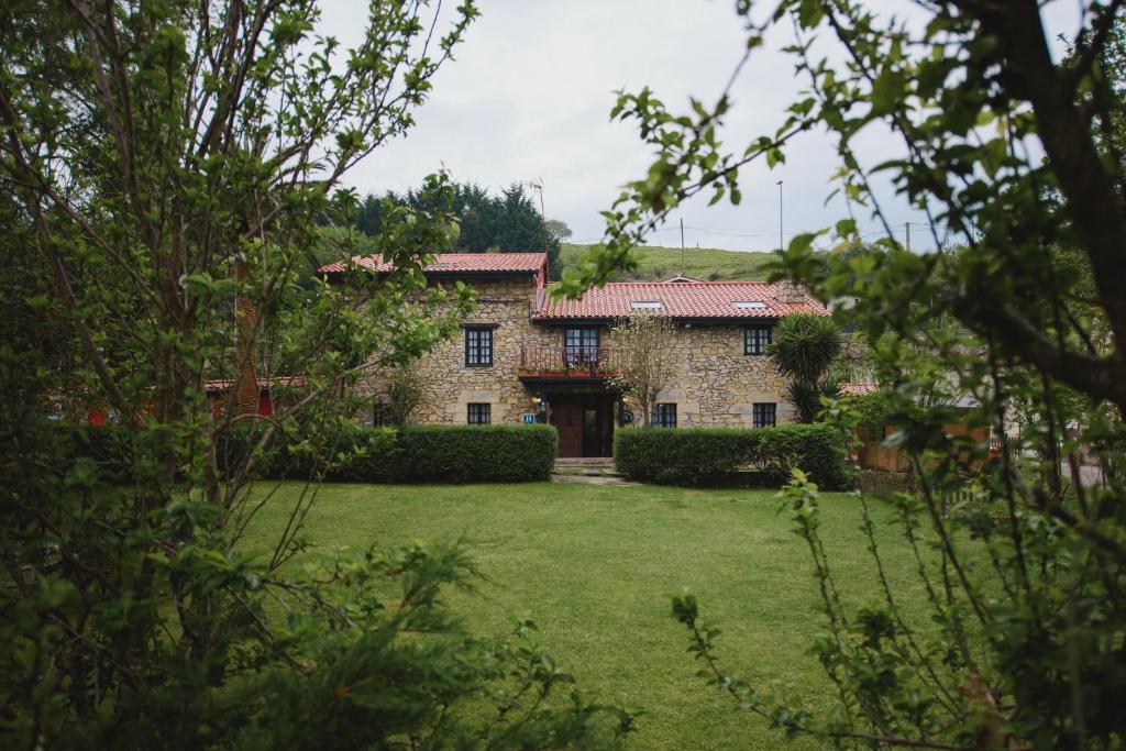 a large stone house with a yard at La Joyuca Del Pas in Mogro