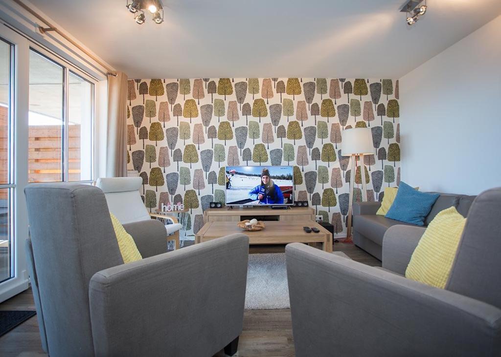 a living room with a couch and a tv at Ferienwohnung Panoramablick Postwiese in Winterberg-Neuastenberg in Winterberg