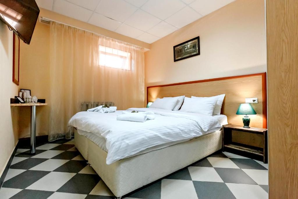 a bedroom with a large bed and a checkered floor at Hotel A3 in Kislovodsk