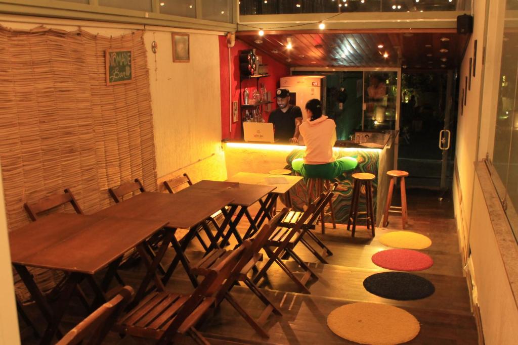 a woman sitting at a table in a restaurant at Nomade In Arte e Hostel São Paulo in Sao Paulo