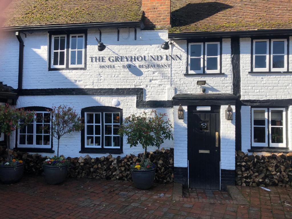 a blue and white building with a black door at The Greyhound Inn in Gerrards Cross