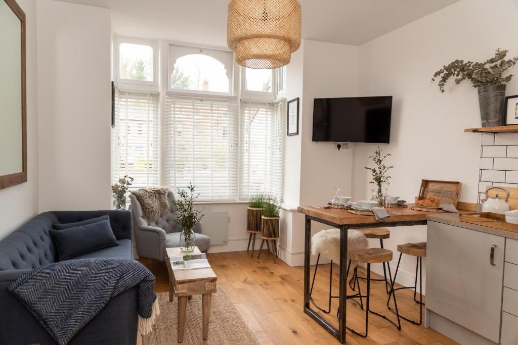 a living room with a blue couch and a table at Finest Retreats - The Cotton Rooms in Matlock