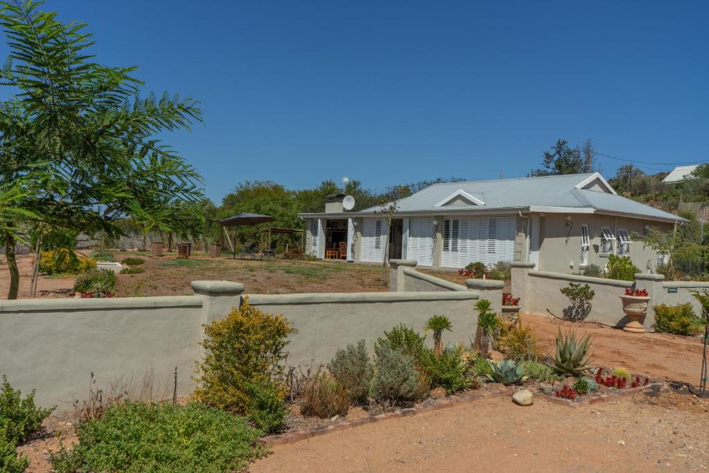 a house with a retaining wall and a garden at Gasteria Grange in Calitzdorp