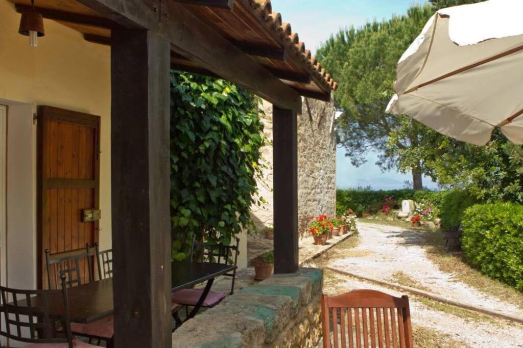 a patio with a table and an umbrella at Dépendance Viburni in Alghero