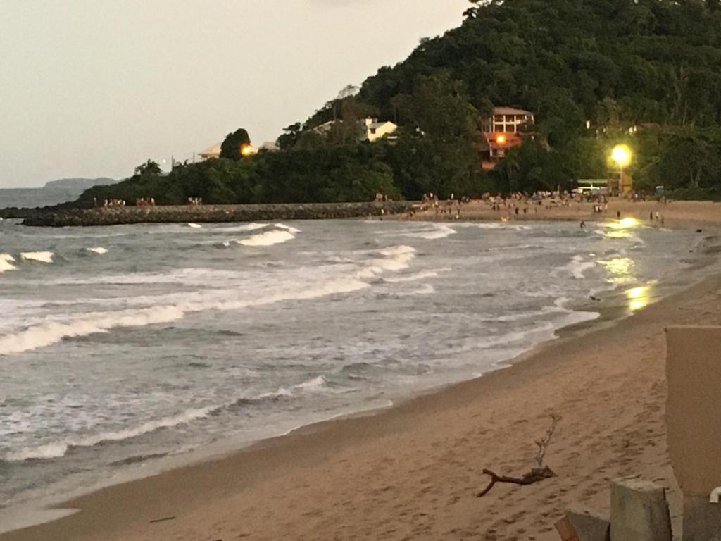 a beach at night with people in the water at Casa BEIRA MAR Praia do Grant em Barra Velha-SC in Barra Velha