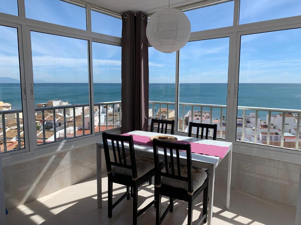 een eetkamer met een tafel en stoelen en de oceaan bij Palm Beach 7th - La Carihuela in Torremolinos