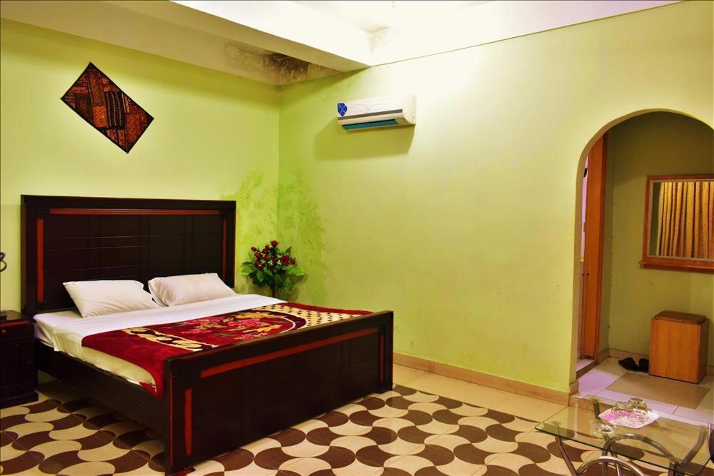 um quarto com uma cama num quarto em River Palace Hotel em Suat