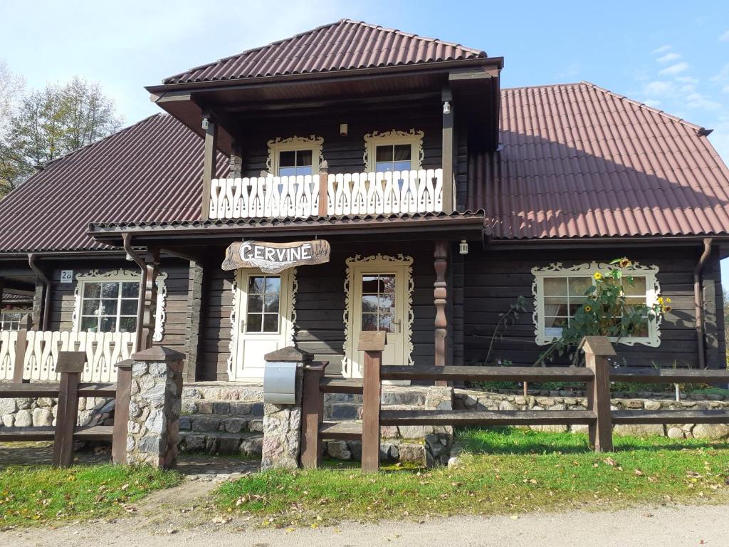 a log house with a balcony on top of it at Sodyba "Gervinė" in Ginučiai