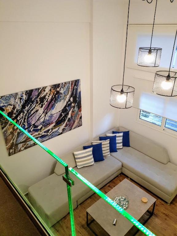 a living room with a couch and a painting at City House Loft in Kalamata