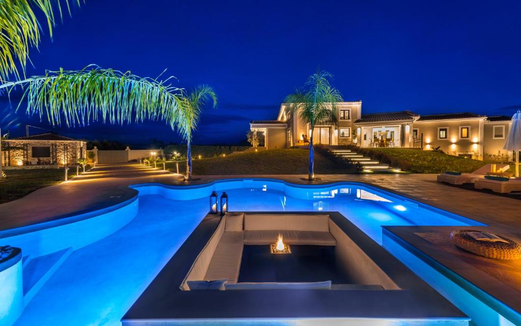 a house with a swimming pool at night at Villa Shangri-La Zakinthos in Zakynthos Town