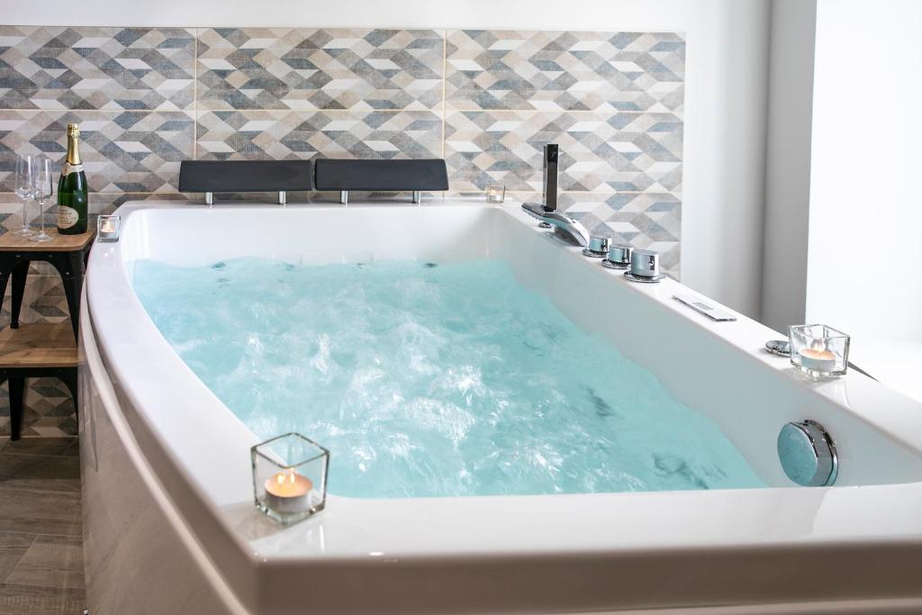 a large bath tub with a candle in it at Chablis SPA : duplex Grand Cru in Chablis