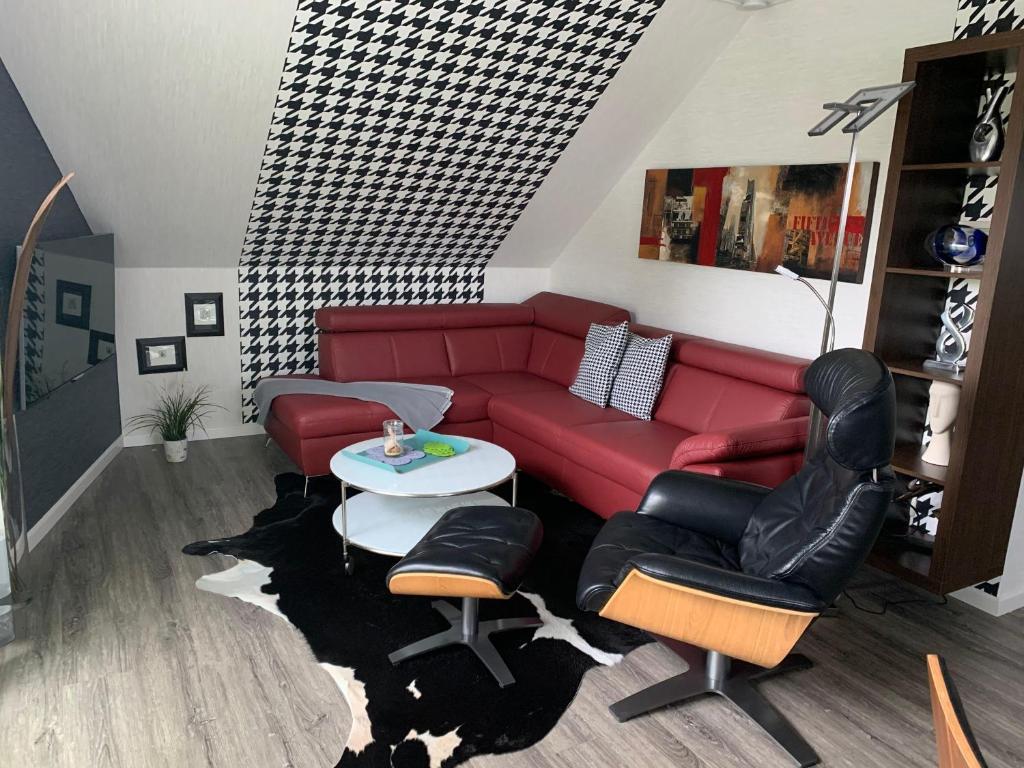 ビューズムにあるHaus-Encore-Wohnung-4のリビングルーム(赤いソファ、椅子付)