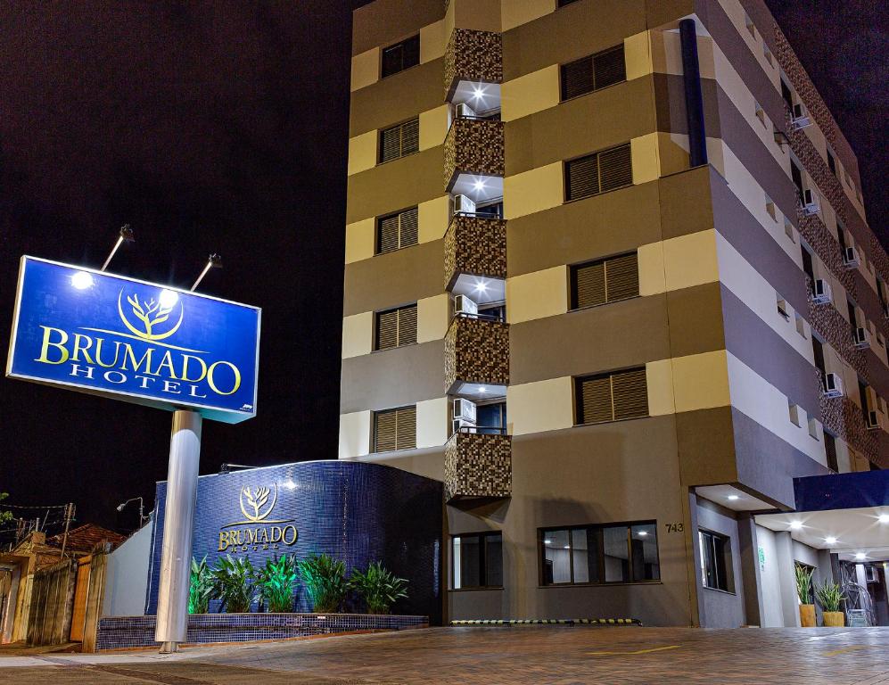 una señal de hotel frente a un edificio en Brumado Hotel, en Campo Grande