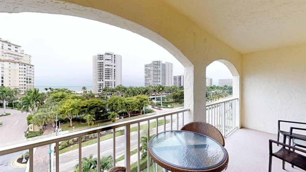 a balcony with a table and chairs and a view of the city at Top floor condo, steps away from JW Marriott and Beach Access!! in Marco Island