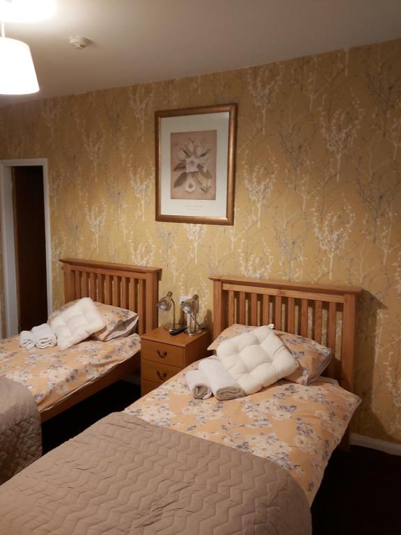 a bedroom with two beds and a picture on the wall at The White Swan in Hunmanby
