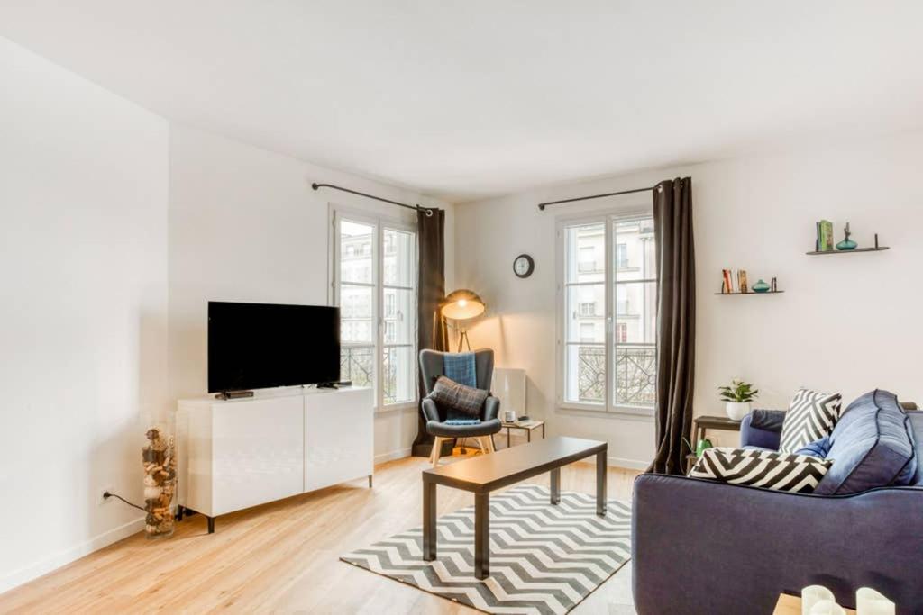 ein Wohnzimmer mit Sofa und Fernseher in der Unterkunft La Serrisienne 3 - Val d'Europe Place Toscane - Disneyland Paris - 4 à 6 Personnes in Serris