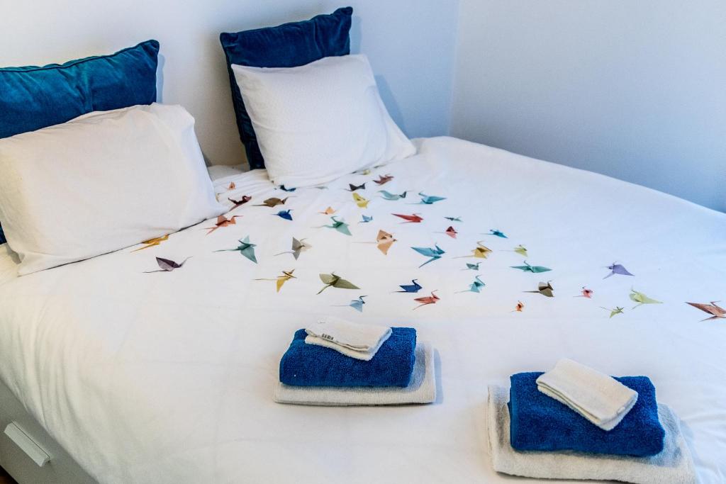 a bed with butterflies on it with towels on it at B&B 1 uit de 100 in Ghent