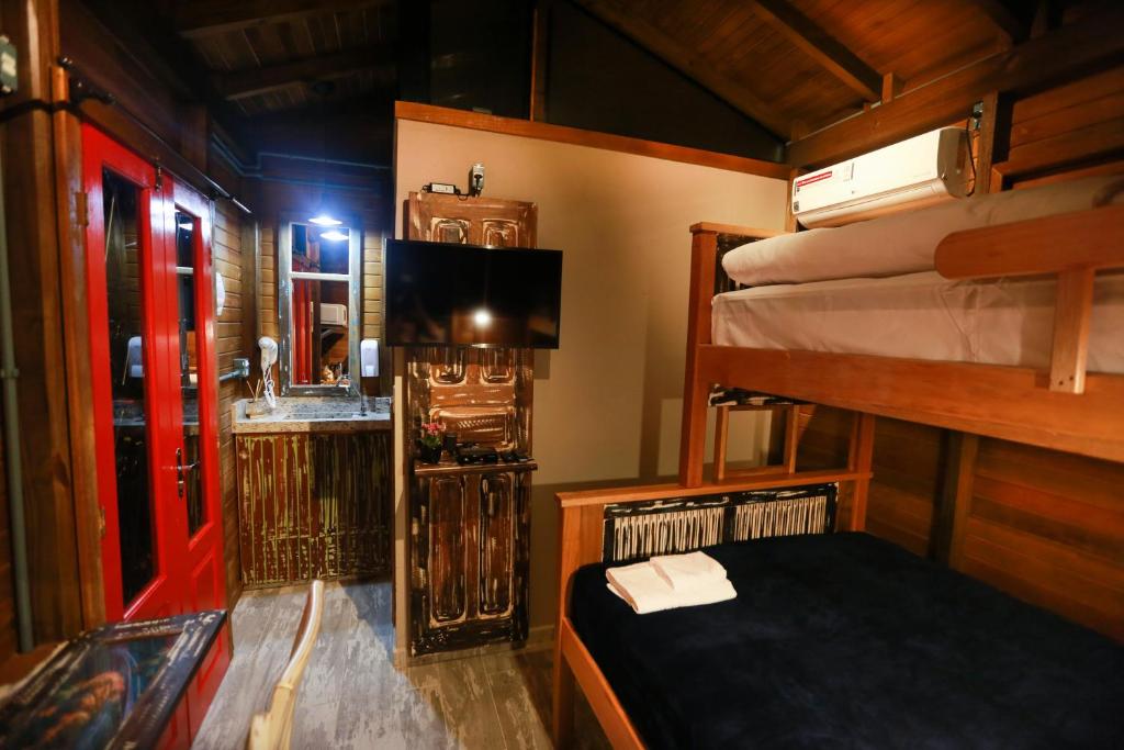 a room with two bunk beds and a sink at Chalés no meu quintal in Lauro Müller