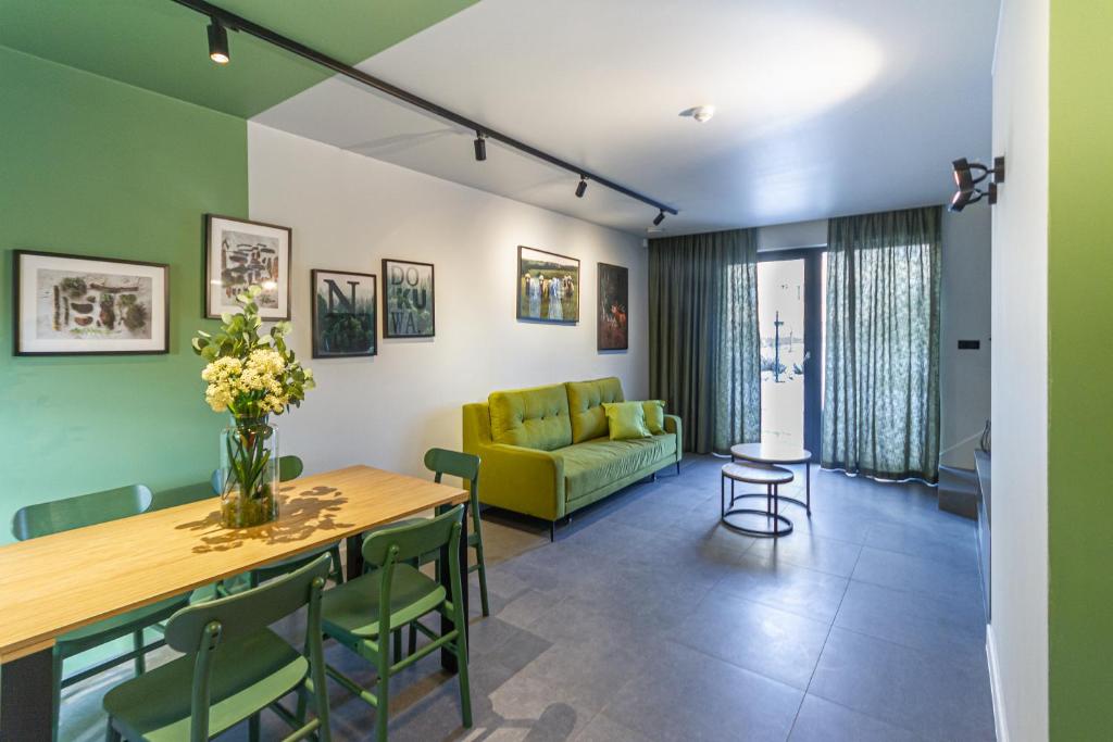 a living room with a green couch and a table at Apartamenty Caminski Deluxe in Kudowa-Zdrój